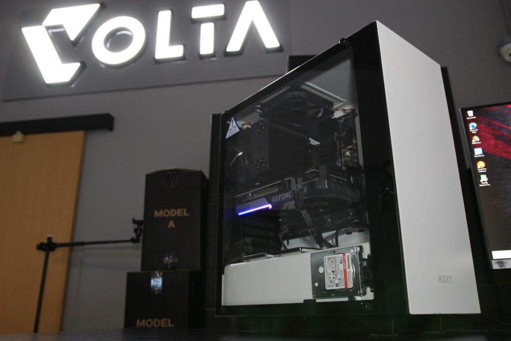 A white-cased gaming PC upgraded by VOLTA PC, featuring powerful new hardware components and a sleek design, sitting on a table.
