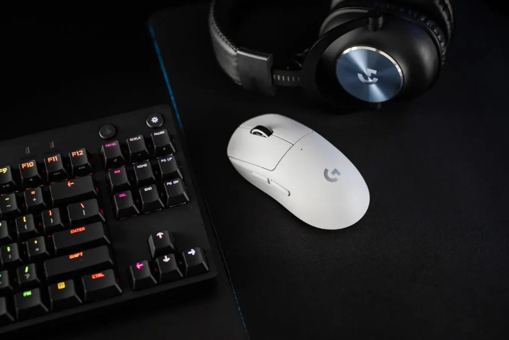 An image of the Logitech G Pro X Superlight, featuring a minimalist black and white design. The mouse is positioned on a white mouse pad and includes various buttons and a scroll wheel. The Logitech G logo is prominently displayed on the palm rest area.