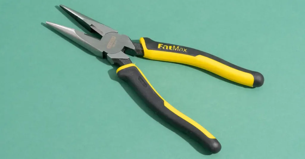 Needle-nose pliers being used during a gaming PC assembly to grip small components and cables.